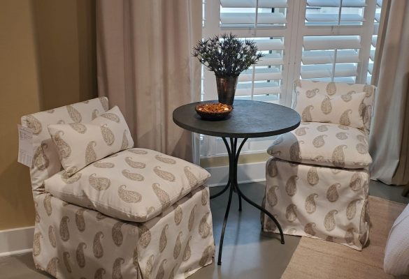 a table surrounded by two chairs with open window and curtains in background